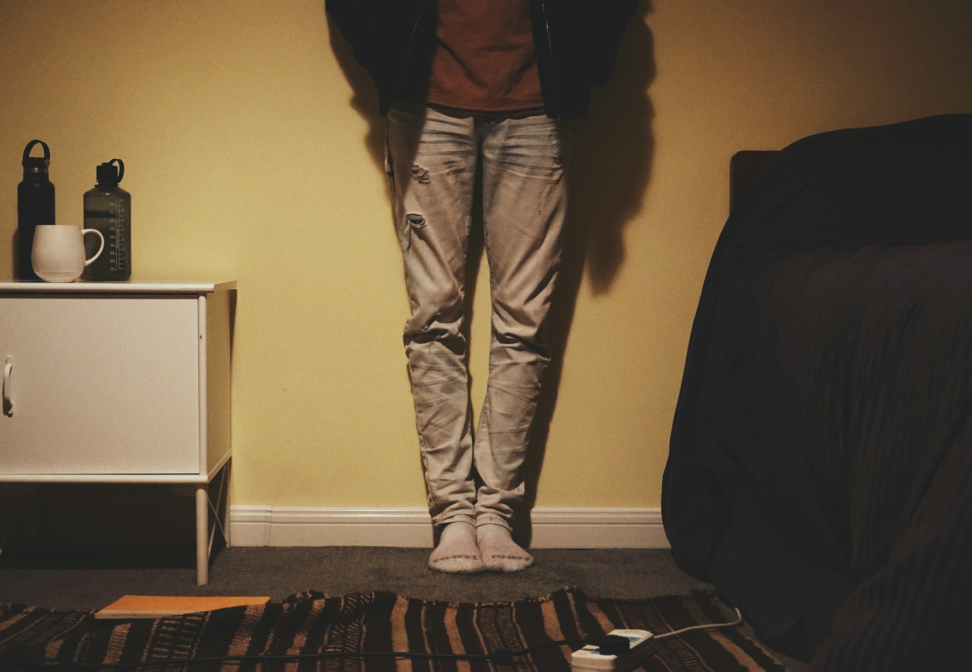 a person standing in front of a yellow wall